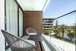 Un balcon donnant sur un bâtiment moderne et sur une étendue d’eau.