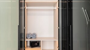 A modern, minimalist room with a glass door, a white shelving unit, and a safe. - Sunshine by Villacarte (Choeng Thale)
