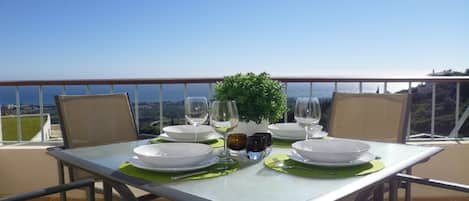 A dining table set for two with a view of the city.
