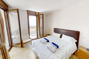 A hotel room with a bed, a chair, a nightstand, and a window with curtains. - Sunlit Marbella Apartment Near Sea (Marbella)