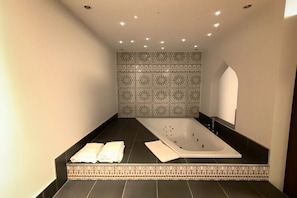 Une salle de bain avec une baignoire, un porte-serviettes et des carreaux décorés.
