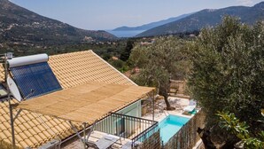 Una vila amb piscina, panells solars i vistes al mar i a les muntanyes.