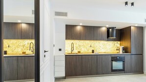 Una cocina moderna con armarios de madera oscura, salpicadero de granito y electrodomésticos integrados.