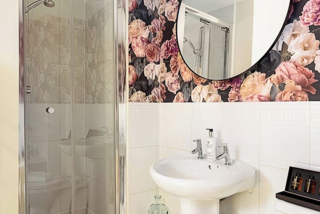 A bathroom with a shower, a sink, and a mirror.