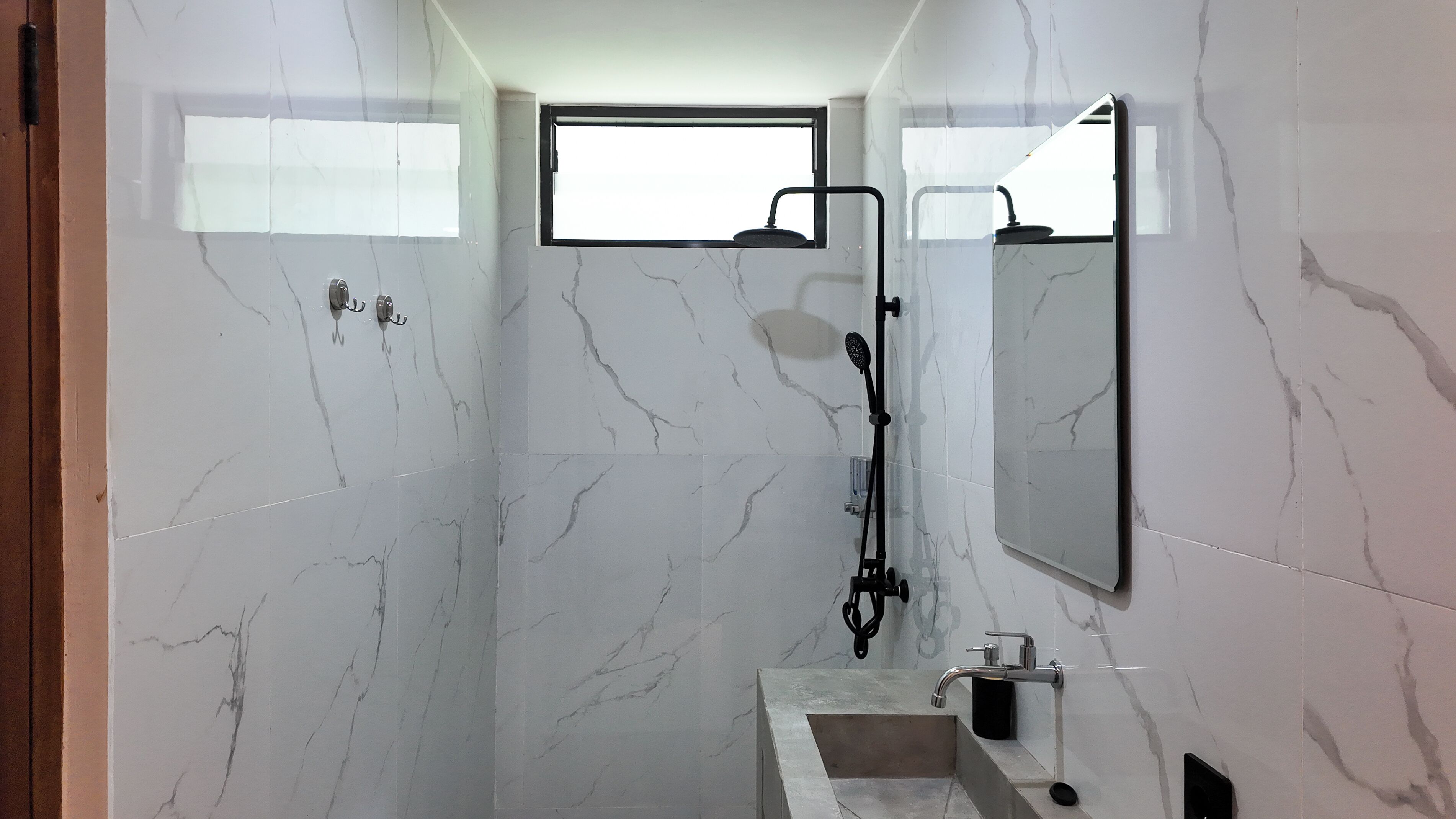 A modern bathroom with a shower, a sink, and a large mirror.