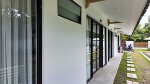 A modern building with large glass windows and a covered walkway. - Pulau Indah Lombok Hotel (Kuta)