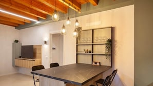 A modern kitchen with a large island, wooden cabinets, and pendant lighting. - Bohemia Apartment (Calmasino)