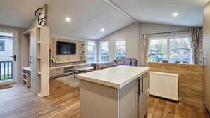 Una cucina moderna con isola centrale, posti a sedere integrati e TV a parete.
