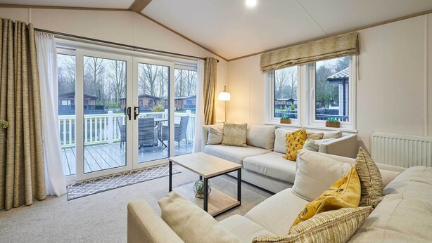 Ein Wohnzimmer mit einer Couch, einem Couchtisch und Blick ins Freie.