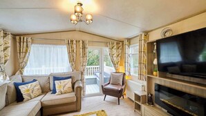 Ein gemütliches Wohnzimmer mit Sofa, Sessel und TV-Möbel.