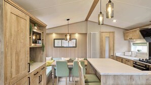 Una cocina moderna con armarios de madera, una isla central e iluminación colgante.