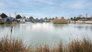 Blick auf einen See mit Mobilheimen und einer Springbrunnen.