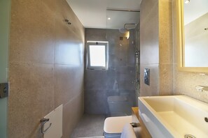 A modern bathroom with a large bathtub, a shower, and a toilet. - Bella Pais Hotel (Maleme)
