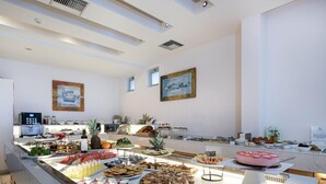 Un buffet proposant une variété de fruits, de viennoiseries et un gâteau.