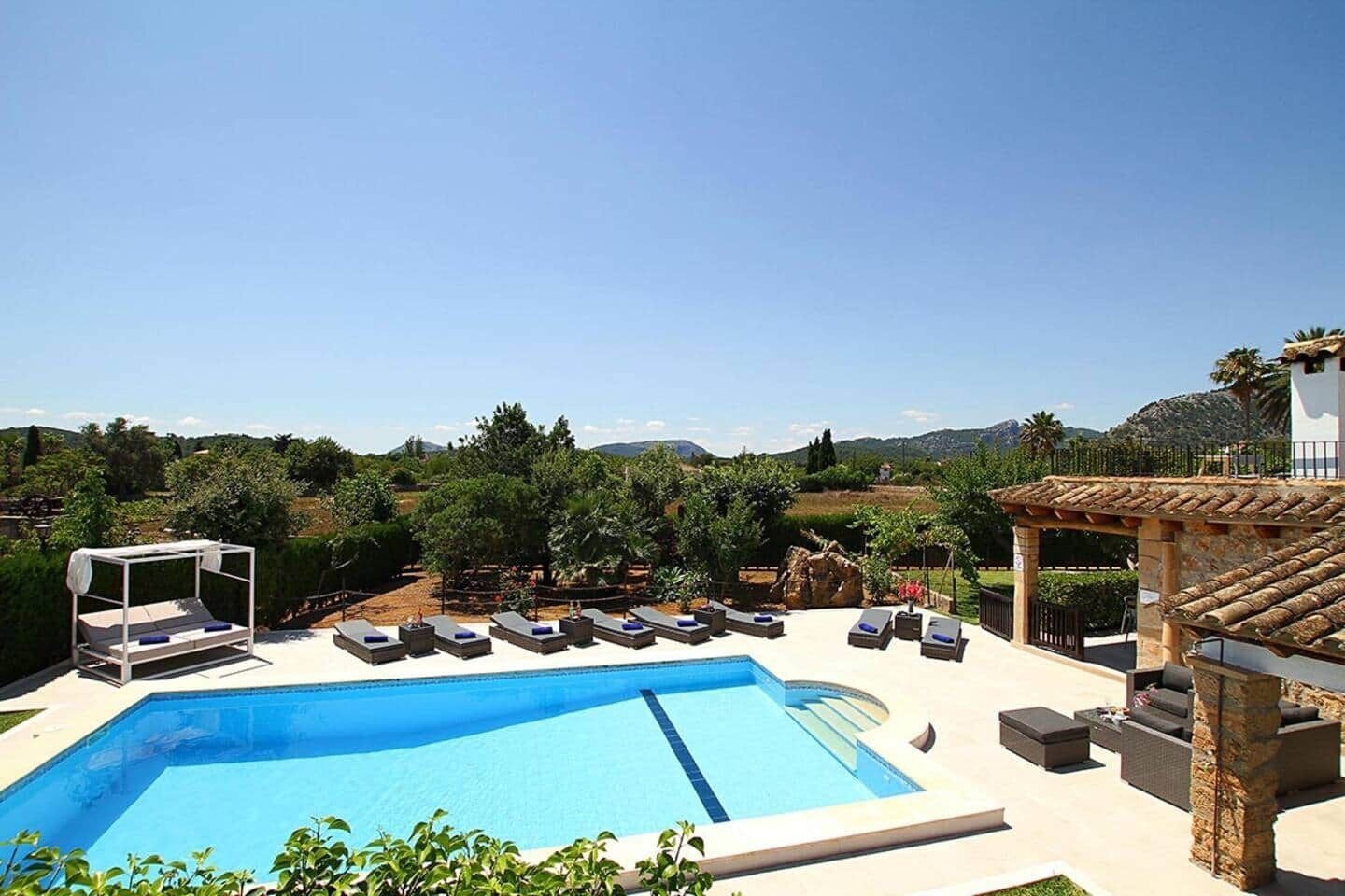 Une piscine avec des chaises longues et une pergola.