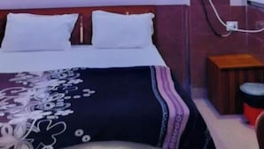 A bedroom with a bed, a ceiling fan, and a wall-mounted air conditioning unit. - Shri Bhagat Ji Seva Dham (Vrindavan)