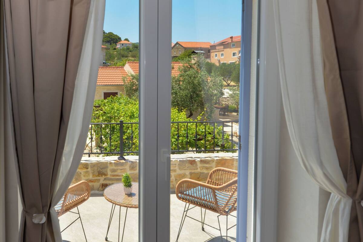 A room with a sliding glass door leading to an outdoor patio with a table and chairs.