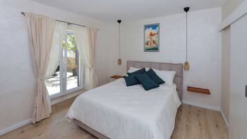 Un dormitorio con cama, cortinas, un cuadro y una lámpara en el techo.