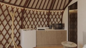 A compact bedroom with a bed, bedside table, and a small kitchenette with a microwave and kettle. - Big Sky Lodge (Ulaanbaatar)