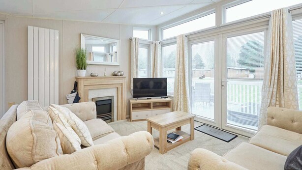 Een woonkamer met een open haard, een televisie en comfortabele zitplaatsen.