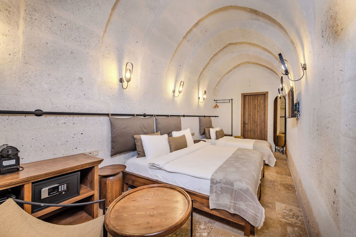 A room with a bed, bedside table, and a safe.