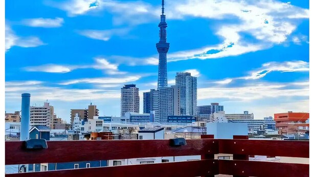 Une vue urbaine avec une tour imposante, divers bâtiments et un ciel dégagé.