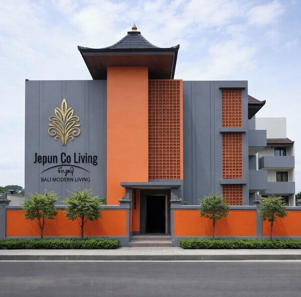 Un bâtiment moderne doté d’une entrée imposante, portant l’inscription « Japun Co Living Bali, un style de vie moderne ».
