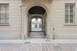 A building entrance with a metal gate, a brick pathway, and a number '61' sign. - Residence in Como with 1 bedrooms sleeps 4 (Como)