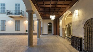 A courtyard with stone columns, a gated entrance, and a building with balconies and shutters. - Residence in Como with 0 bedrooms sleeps 2 (Como)