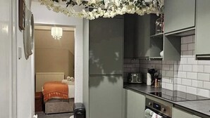 A compact kitchen with grey cabinets, a built-in oven, and a microwave. - Stylish 2-Bed Apartment in the Heart of Windsor – Walk to Windsor Castle (Windsor)