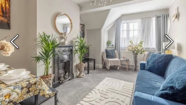 A living room with a fireplace, sofa, and dining area. - Stylish 2-Bed Apartment in the Heart of Windsor – Walk to Windsor Castle (Windsor)