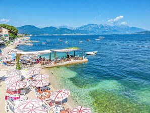 A coastal area with clear waters, a pier with tables and umbrellas, and boats in the background. - Wohnung "Studio" ohne Terrasse by Interhome (Herceg Novi)