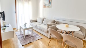 Un saló modern amb un sofà, una taula de centre i una taula de menjador amb cadires.