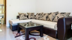 Ein stilvolles Wohnzimmer mit einer Couch, einem Couchtisch und einem gemusterten Teppich.