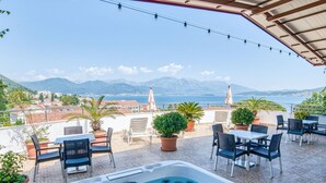 A rooftop terrace with a hot tub, outdoor seating, potted plants, and a view of the sea and mountains. - Wohnung "Premier" mit Meerblick by Interhome (Herceg Novi)