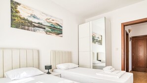 A hotel room with two beds, a large mirror, and a painting of a landscape. - Wohnung "Premier" mit Meerblick by Interhome (Herceg Novi)