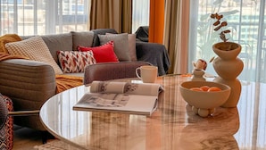 Een moderne woonkamer met een bank, salontafel en decoratieve objecten.