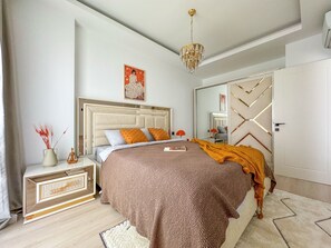 Une chambre à coucher moderne avec un grand lit, une table de chevet, un miroir et un lustre.