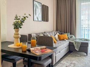 A modern living room with a sofa, a coffee table, a vase with a plant, and a magazine. - Qoople Aria-32 neue Wohnung im Stadtzentrum by Interhome (Alanya)