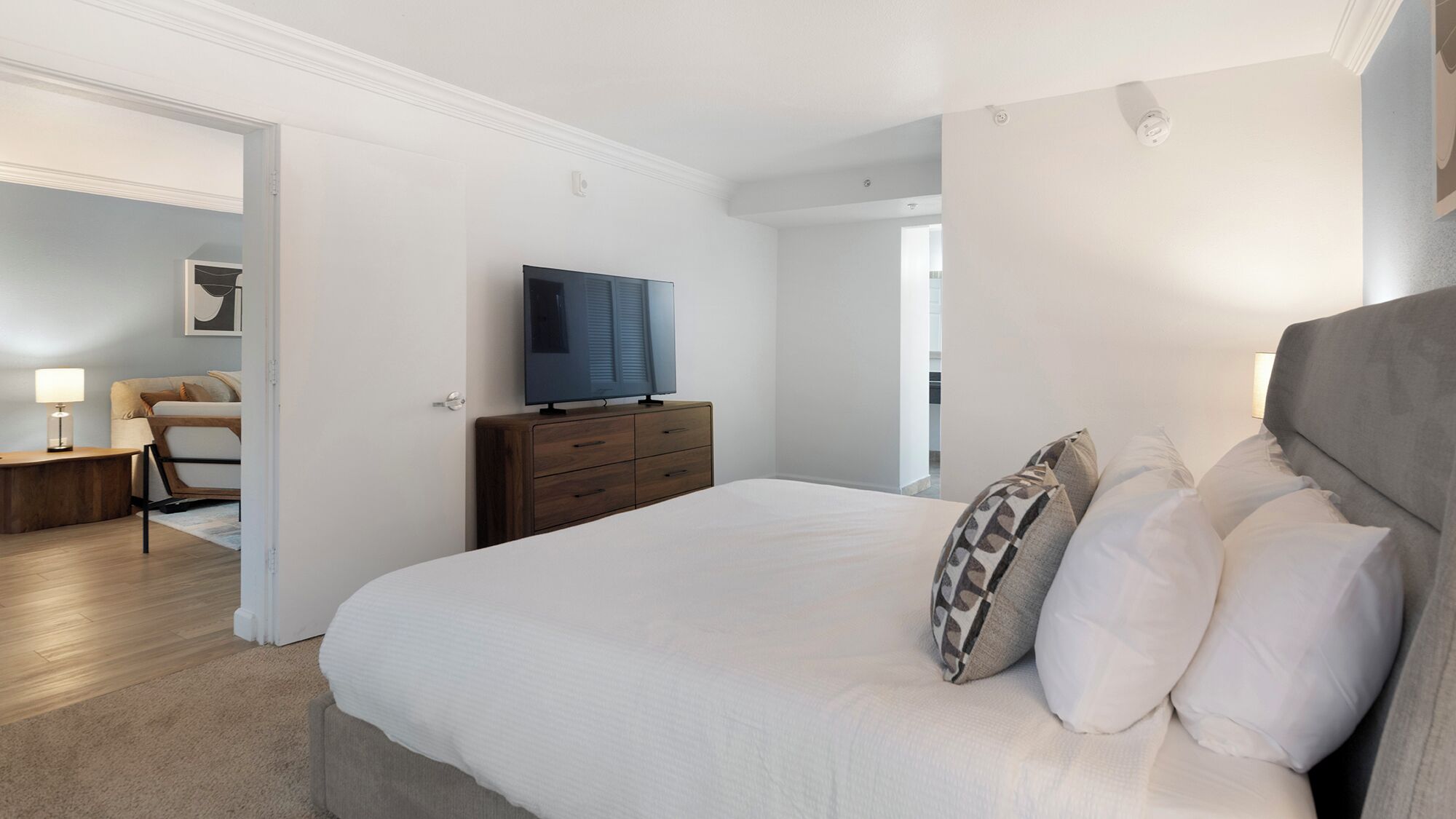 Ein Schlafzimmer mit Bett, Fernseher, Kommode und Stuhl.