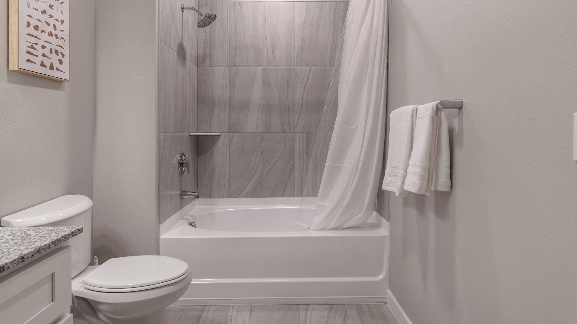 A bathroom with a toilet, a bathtub, and a shower.