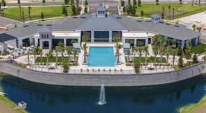 A modern hotel with a central pool, surrounded by a stone wall and palm trees. - Landing Furnished Apartments Davenport near Northeast Regional Park (Davenport)