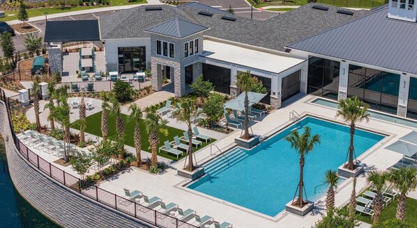 A modern resort with a large pool, lounge chairs, and a well-maintained garden. - Landing Furnished Apartments Davenport near Northeast Regional Park (Davenport)