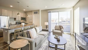 Eine moderne Wohnung mit Küche, Essbereich, Wohnzimmer und Balkon.