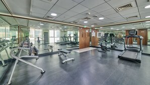 A gym with various exercise equipment, mirrors, and a clean, well-lit interior. - Grand Stay Holidays Homes Rental Satwa (Dubai)