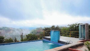 A swimming pool with a view of a mountainous landscape. - Exotica De Swiss Panchgini (Mahabaleshwar)