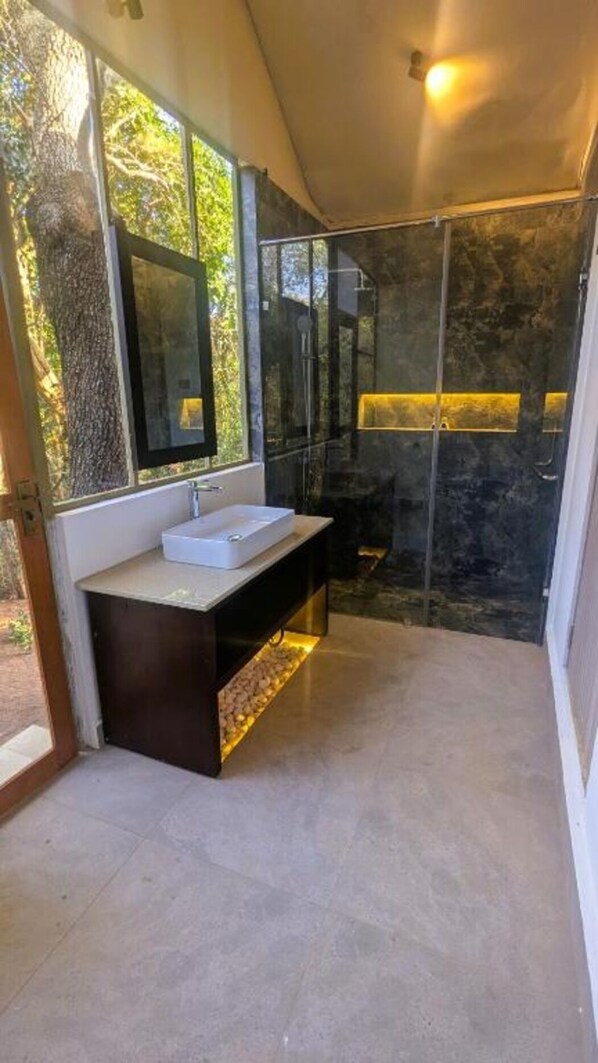 Une salle de bain moderne dotée d’une grande fenêtre, d’un lavabo et d’un espace douche.