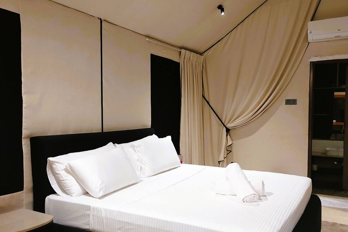 A modern bedroom with a large bed, a bedside table, and a built-in wardrobe.