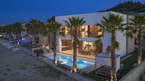 A modern villa with a swimming pool, outdoor seating, and palm trees. - The Palms Resort Villa Waterfront with Pool (Tkon)