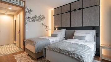 Habitació d'hotel amb dos llits, una finestra gran i una obra d'art penjada a la paret.